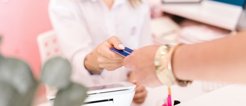Femme donnant sa carte bancaire à une autre femme pour une procuration bancaire