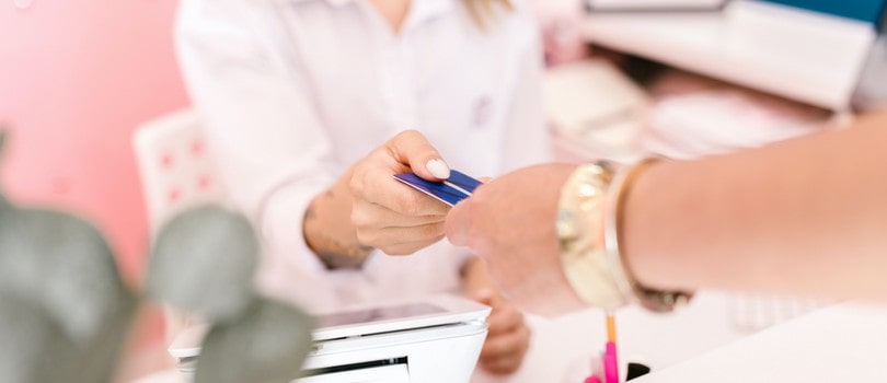 Femme donnant sa carte bancaire à une autre femme pour une procuration bancaire