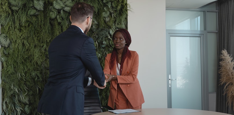 Homme et femme se serrant la main lors d'un entretien d'embauche