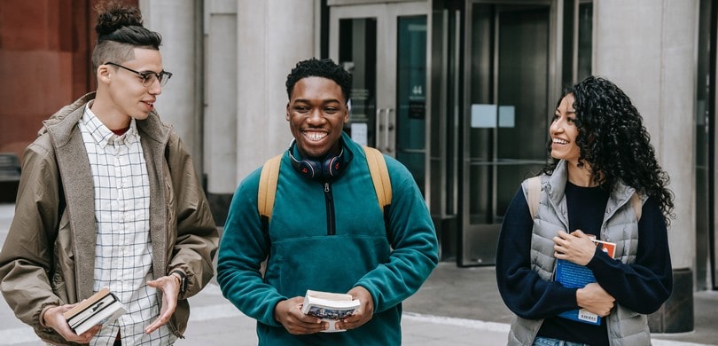 Trois étudiants devant leur école