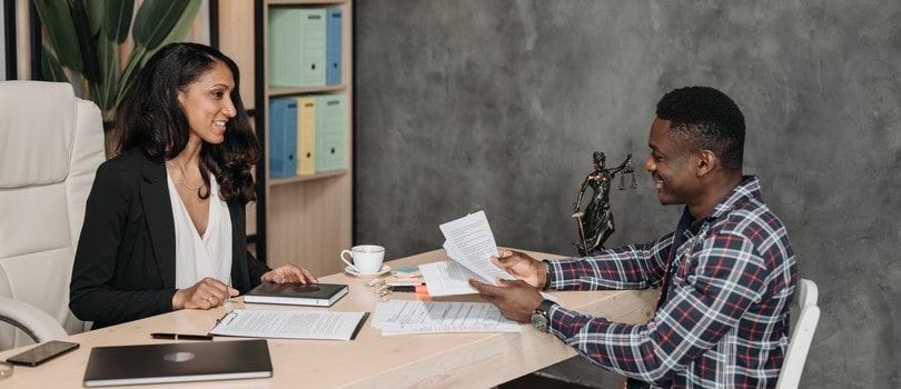 Homme et femme assis à discuter sur un contrat avec une clause de non-concurrence