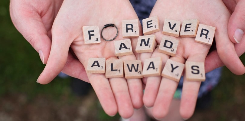 Lettres de scrabble formant "Forever and always" dans les mains d'un couple