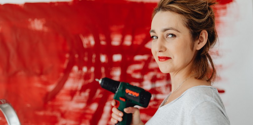 Femme s'apprêtant à percer un mur